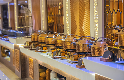close-up of a high-end catering setup showcasing shiny gold food warmers